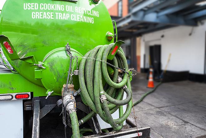 a vacuum truck pumping out a large underground grease trap in Cambridge