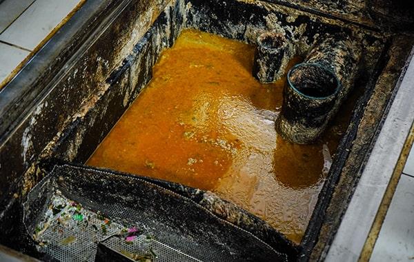 foul odors, slow draining sinks, and visible grease buildup are signs that your grease trap needs cleaning